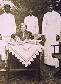 A woman at tiffin, surrounded by servants