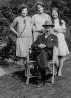 An old photograph of a man seated with his wife and two daughters standing behind him